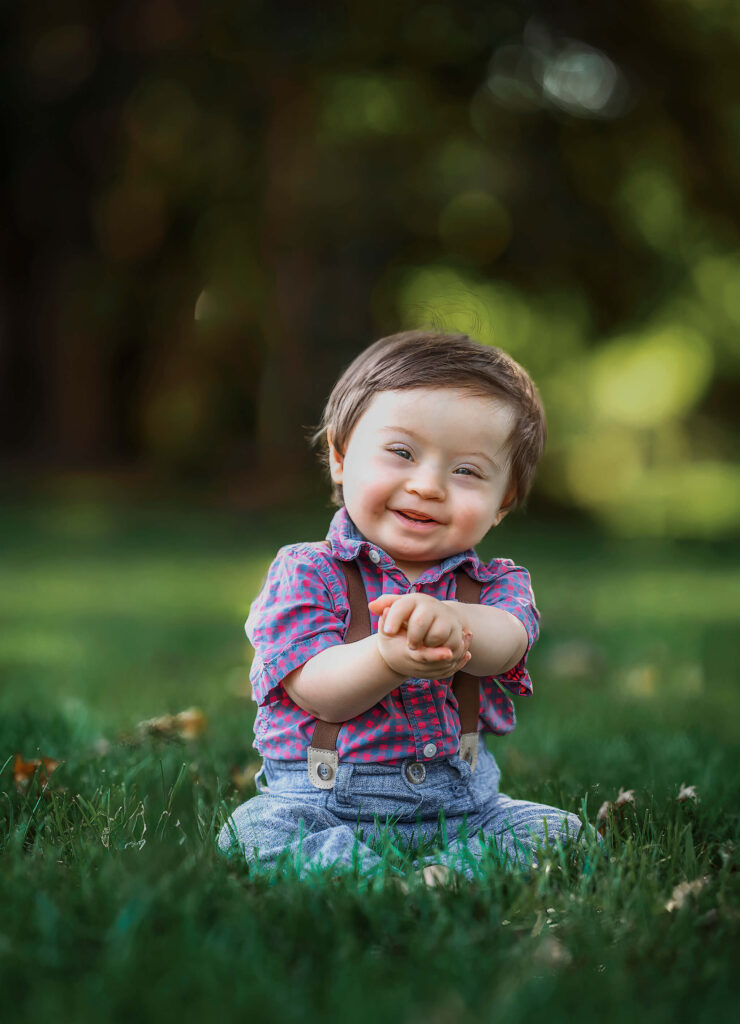 Boy with down syndrome sitting in the grass